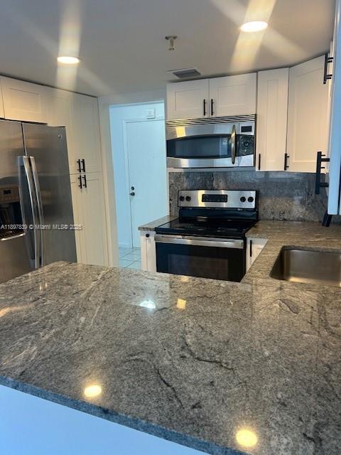 10661 Southwest 108th Avenue, Unit 2E Miami, FL 33176 - Photo 21 of 33 a kitchen with stainless steel appliances a sink a stove a microwave a refrigerator and cabinets