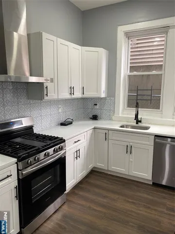 a kitchen with sink stove and cabinets