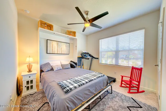 a bedroom with a bed a chandelier and a dresser