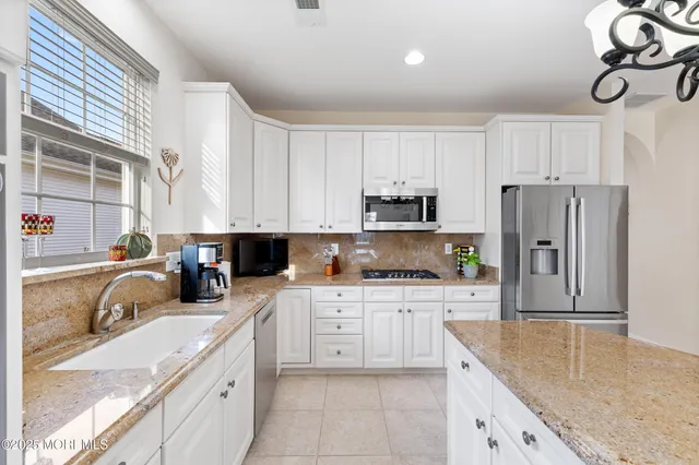 a kitchen with stainless steel appliances granite countertop a stove sink and cabinets