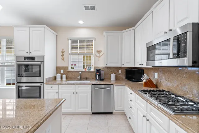 a large kitchen with kitchen island a chandelier and living room view