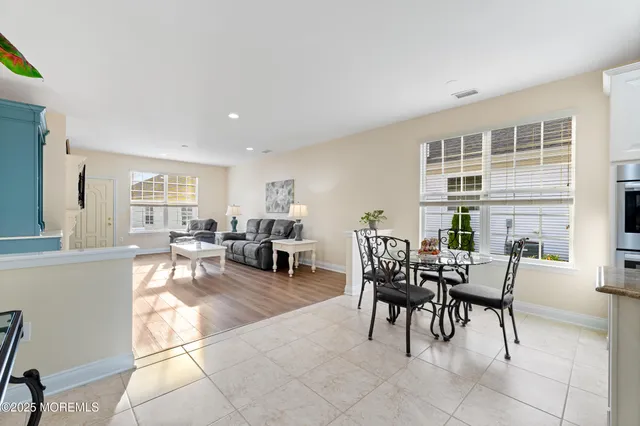 a dining room with furniture and kitchen view