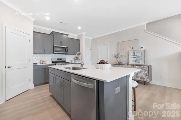 a kitchen with kitchen island a sink stainless steel appliances and cabinets