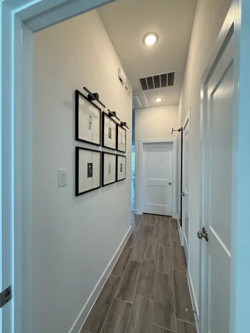 a view of a hallway with wooden floor