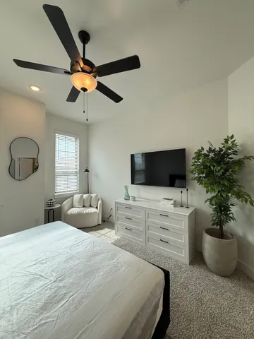 a bedroom with a bed a flat screen tv and a couch