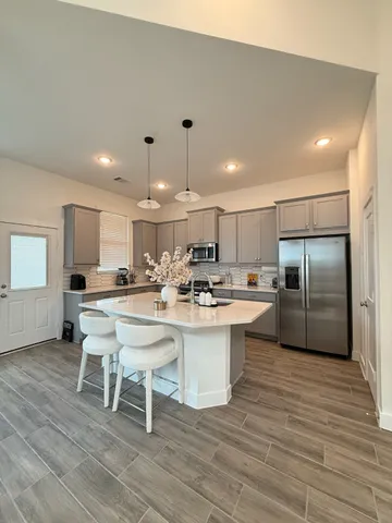 a kitchen with a sink cabinets and wooden floor