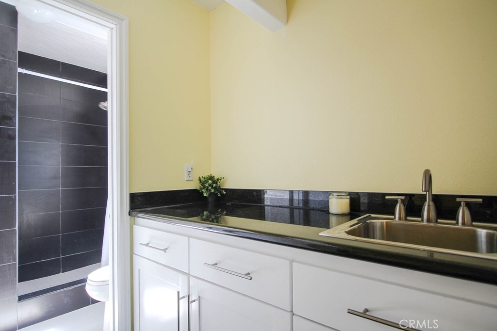 1920 Maple Avenue, Unit A Costa Mesa, CA 92627 - Photo 25 of 35 a bathroom with a granite countertop sink and a mirror