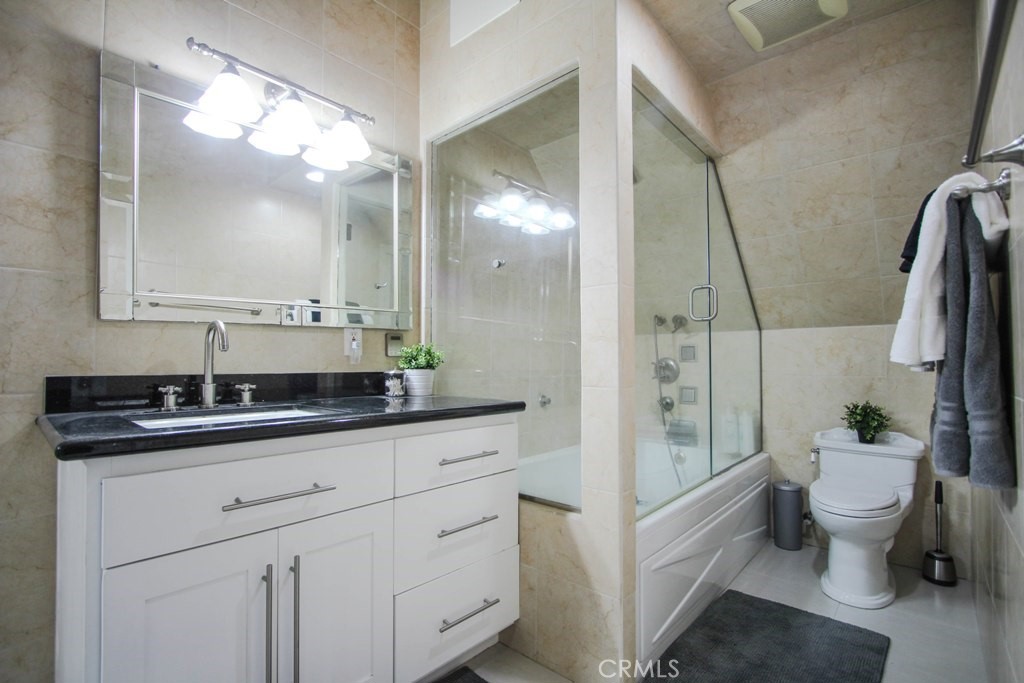 1920 Maple Avenue, Unit A Costa Mesa, CA 92627 - Photo 33 of 35 a bathroom with a granite countertop sink and a mirror