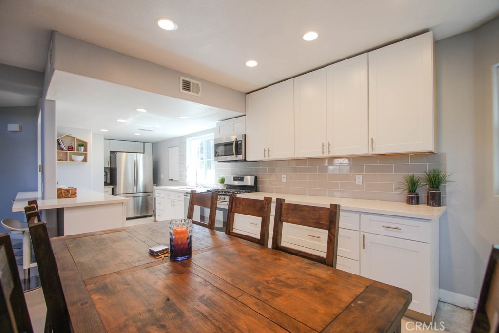 1920 Maple Avenue, Unit A Costa Mesa, CA 92627 - Photo 4 of 35 a large white kitchen with lots of counter space a sink and appliances