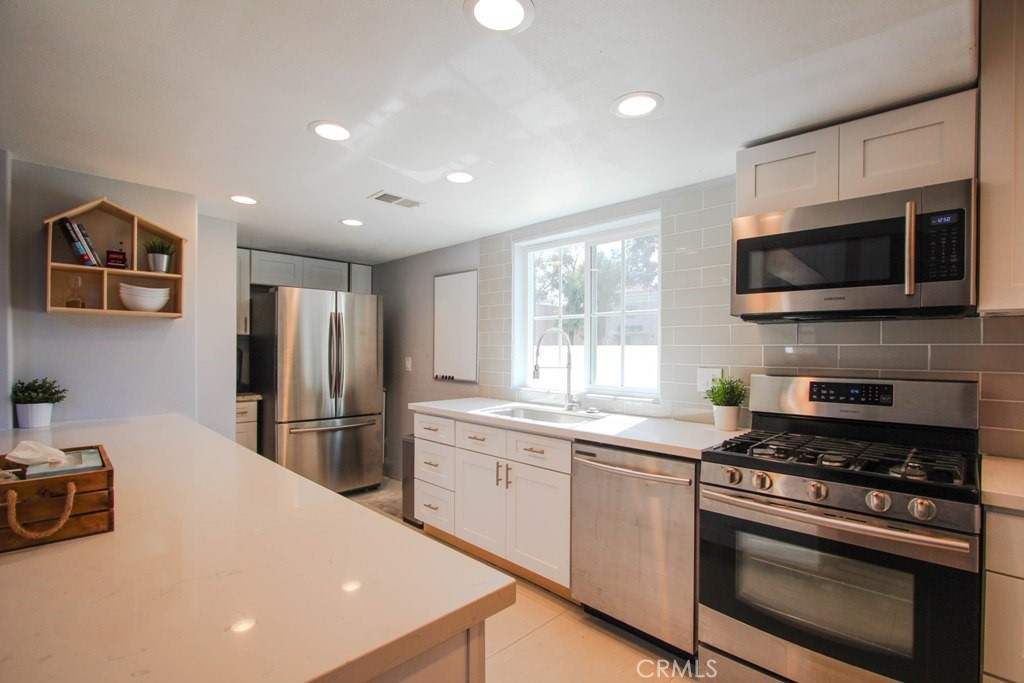 1920 Maple Avenue, Unit A Costa Mesa, CA 92627 - Photo 5 of 35 a kitchen with stainless steel appliances a stove microwave and refrigerator