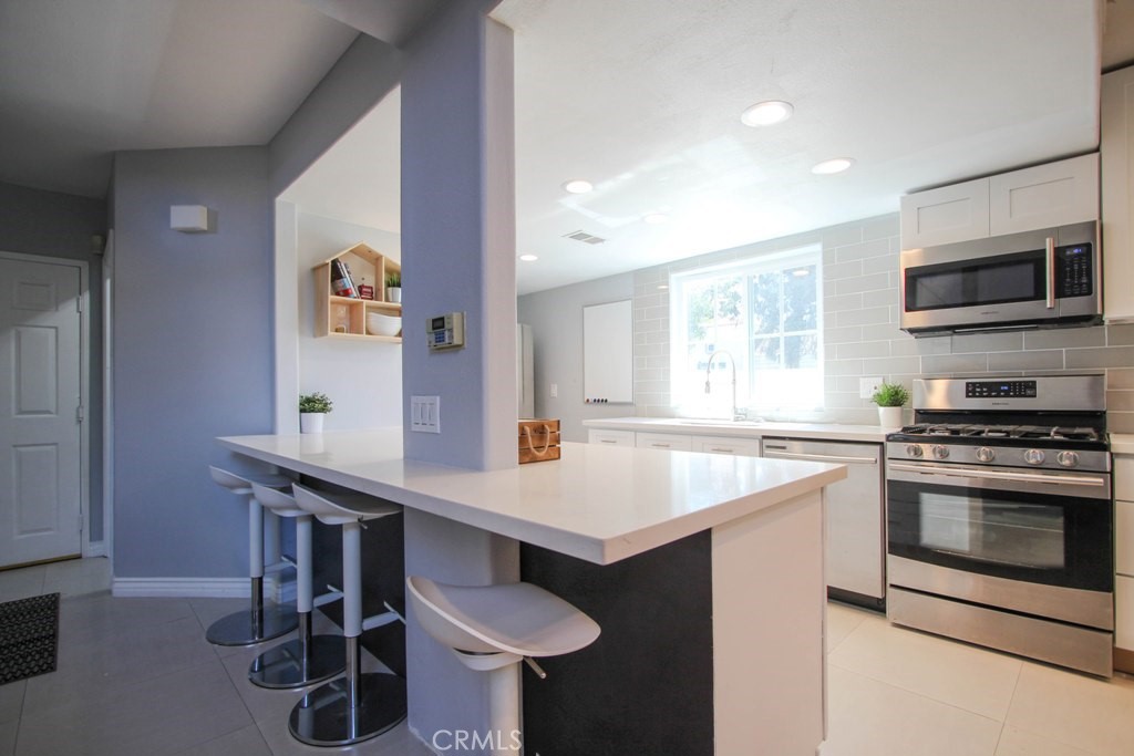 1920 Maple Avenue, Unit A Costa Mesa, CA 92627 - Photo 6 of 35 a kitchen with a stove a sink and a microwave