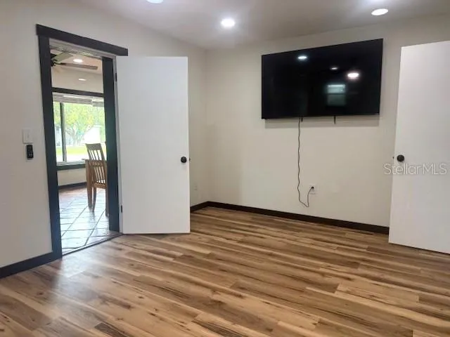 a view of a livingroom with wooden floor and a flat screen tv