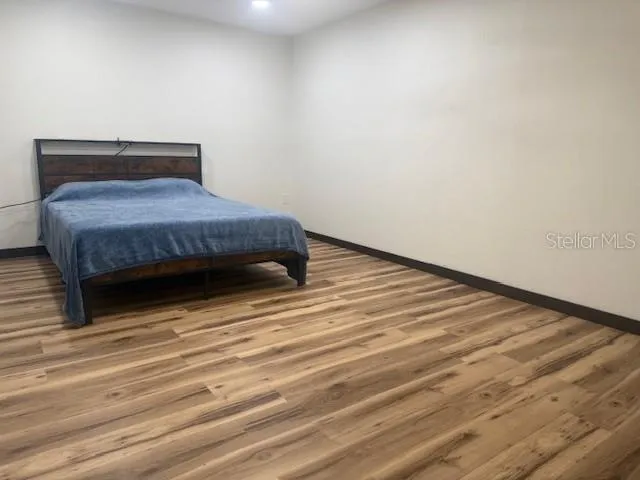 a bedroom with a bed and wooden floor