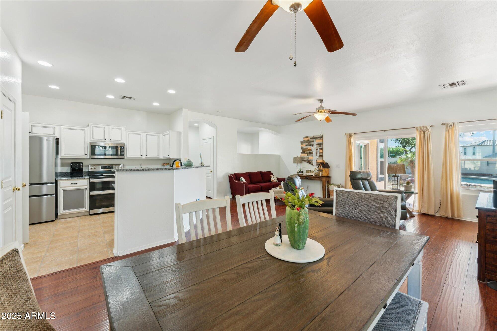 1924 South Rome Street Gilbert, AZ 85295 - Photo 48 of 60 a kitchen with a dining table wooden floor stainless steel appliances and a dining table