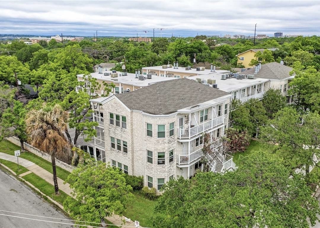 3400 Speedway, Unit 203 Austin, TX 78705 - Photo 1 of 1 Four-story building featuring light-colored brick exterior, multiple balconies, and a dark-shingle roof