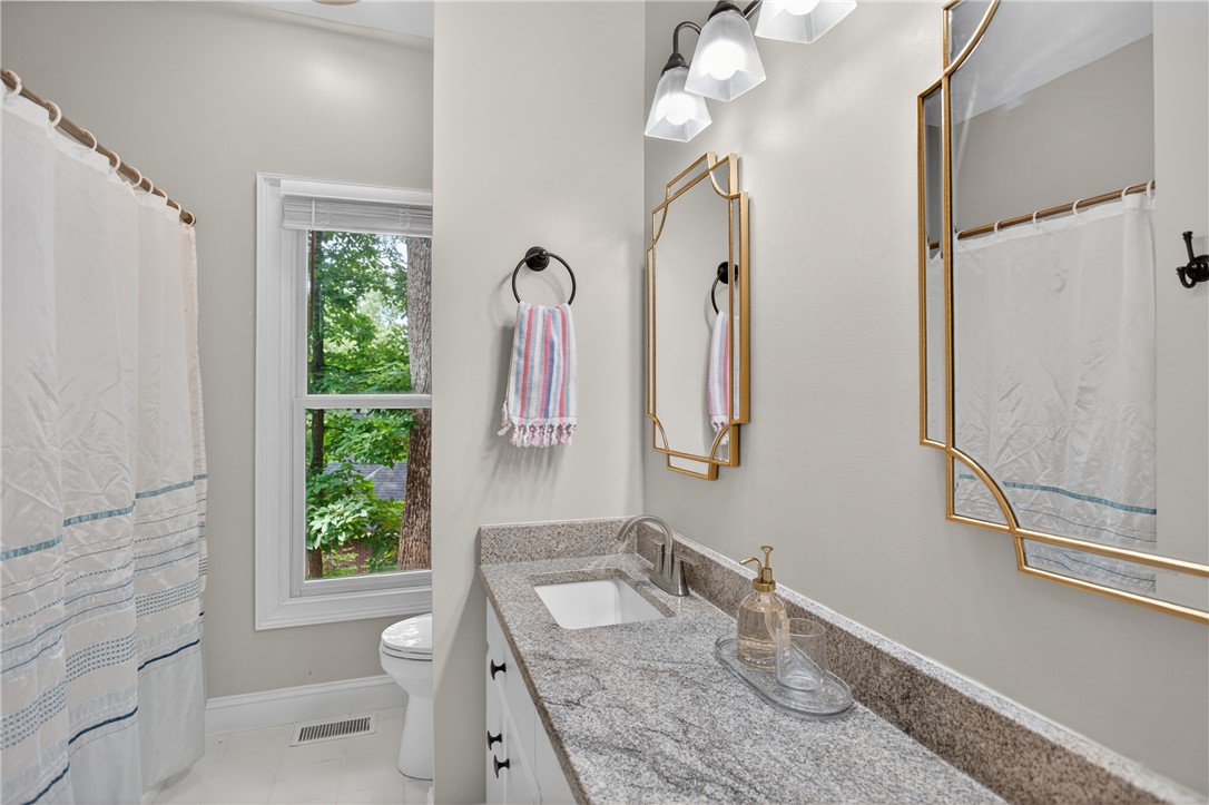 136 Loran Pointe Circle Seneca, SC 29672 - Photo 23 of 50 Granite counters and a framed mirror add refined elegance to this bathroom.