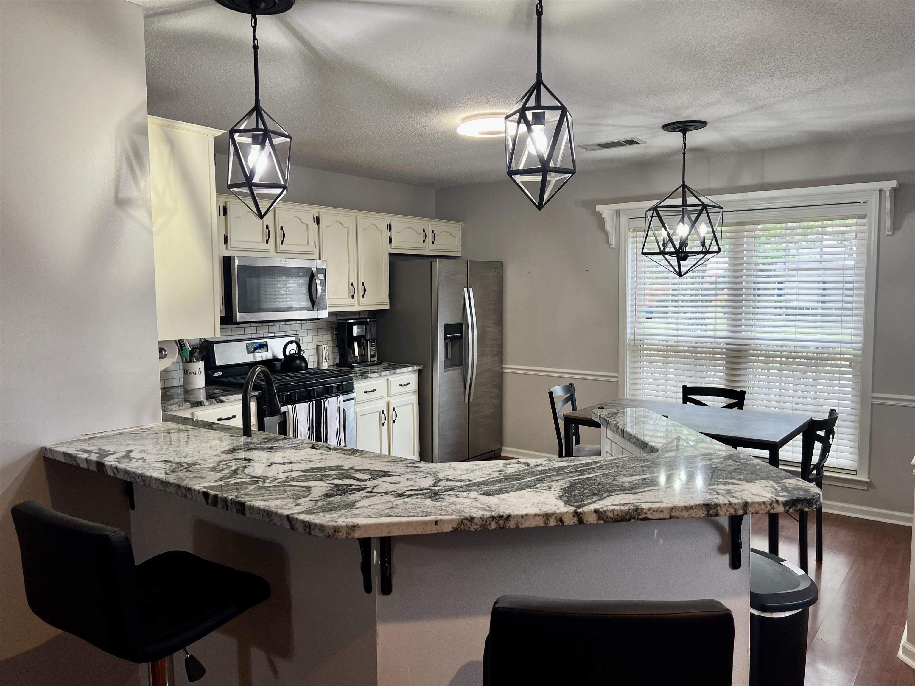 7429 Gingerhill Lane Bartlett, TN 38133 - Photo 5 of 20 a kitchen with kitchen island granite countertop a sink center island and cabinets
