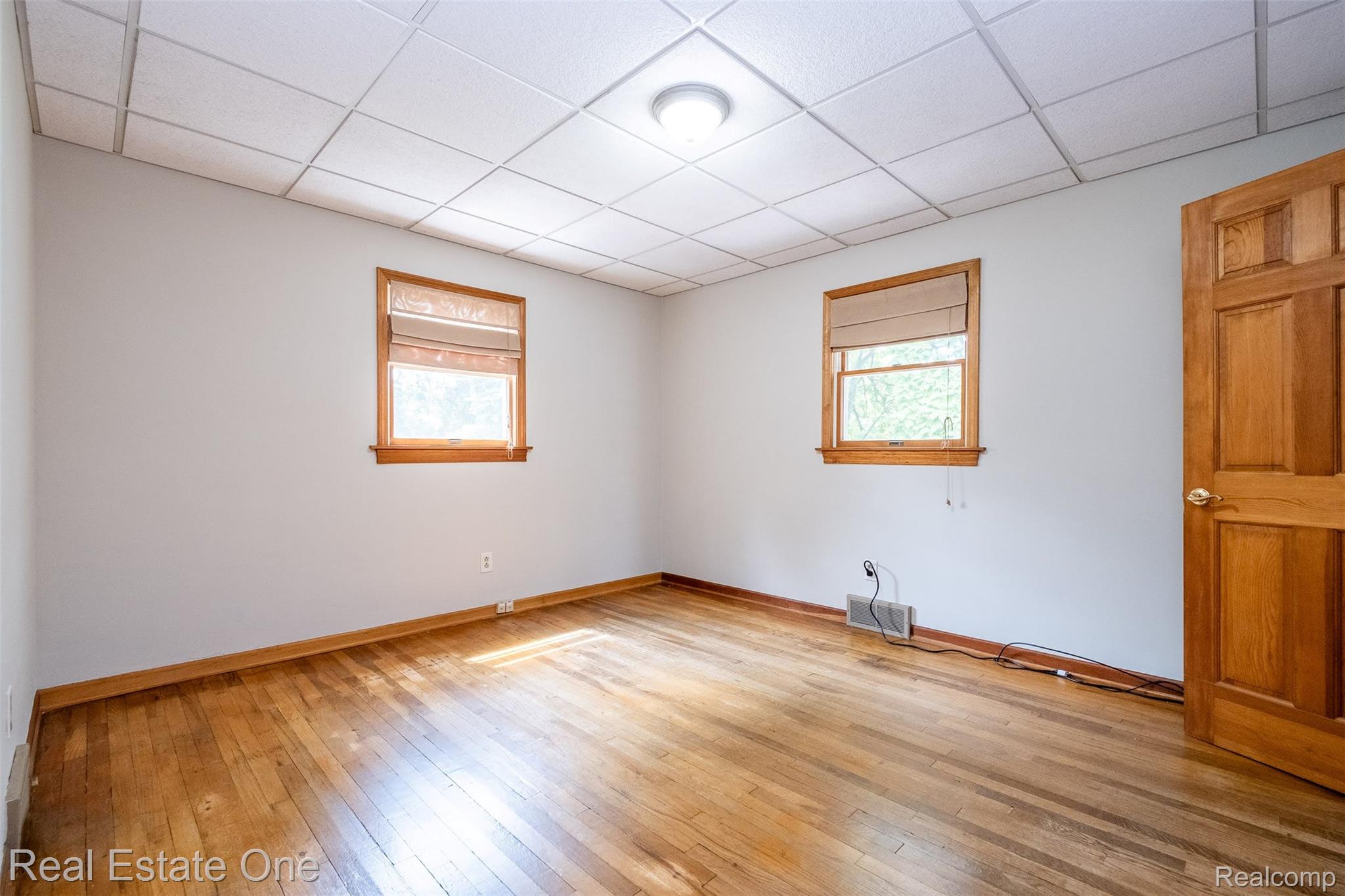 11030 Marshall Road South Lyon, MI 48178 - Photo 41 of 83 Hardwood flooring, wood trim windows, wood panel door, drop ceiling, and recessed lighting