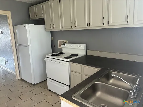 a white refrigerator freezer sitting in a kitchen