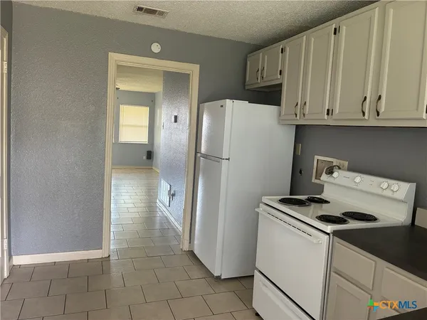 a kitchen with a refrigerator and cabinets