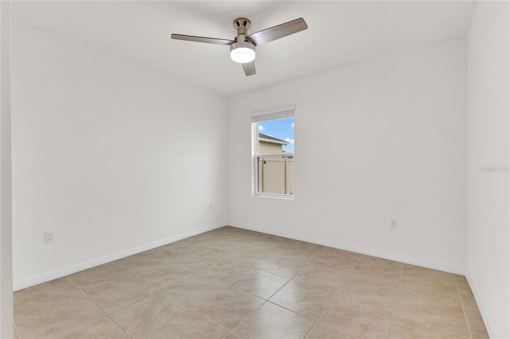 641 Talisi Loop St. Cloud, FL 34771 - Photo 13 of 40 an empty room with a window and a ceiling fan