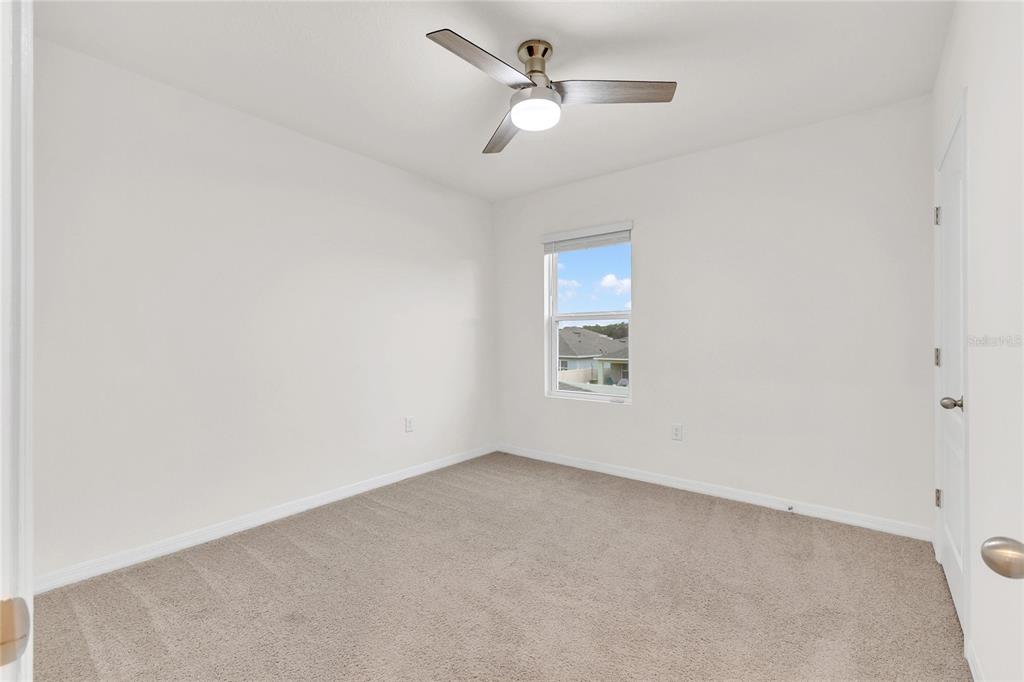 641 Talisi Loop St. Cloud, FL 34771 - Photo 16 of 40 an empty room with a window and ceiling fan