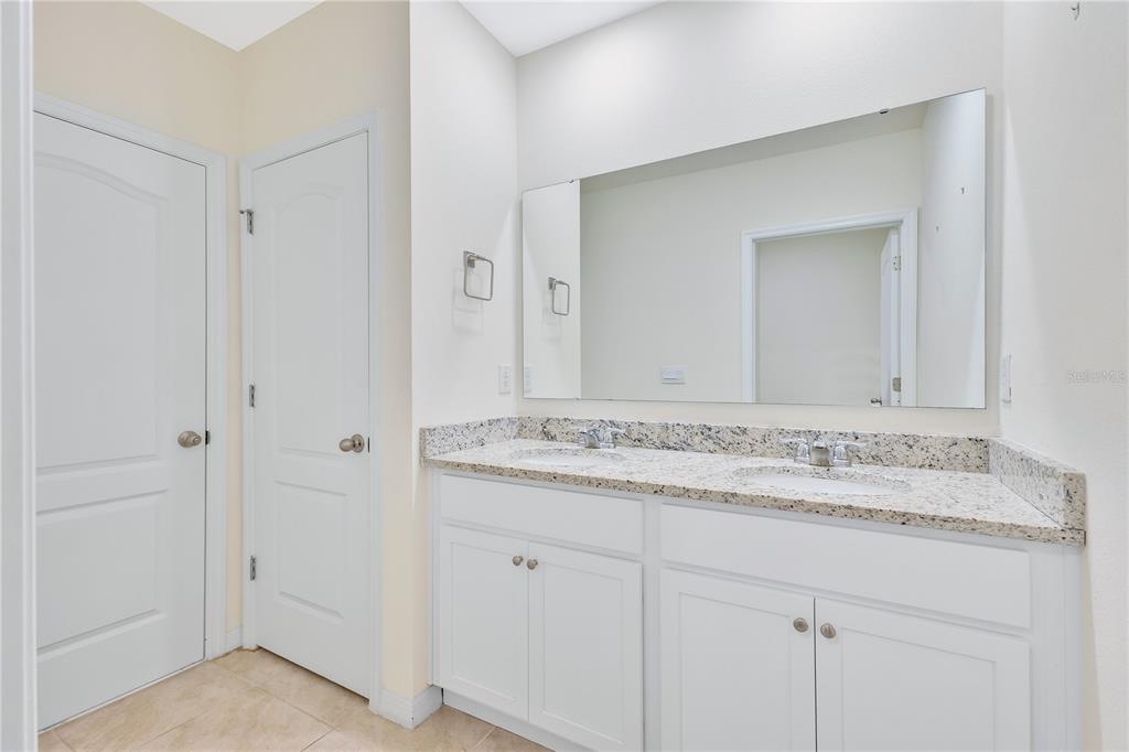 641 Talisi Loop St. Cloud, FL 34771 - Photo 19 of 40 a bathroom with a granite countertop sink and a mirror