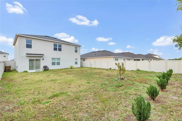 a view of a white house with a yard and table and chairs