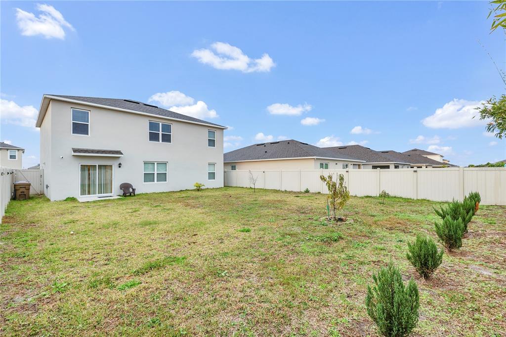 641 Talisi Loop St. Cloud, FL 34771 - Photo 27 of 40 a view of a white house with a yard and table and chairs
