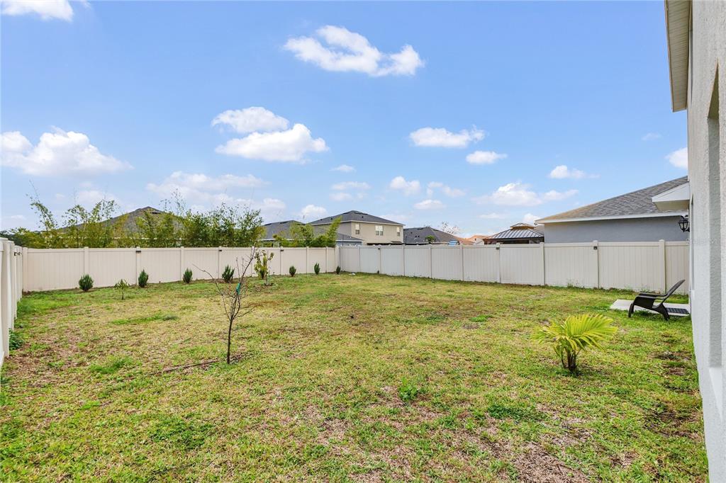 641 Talisi Loop St. Cloud, FL 34771 - Photo 29 of 40 a backyard of a house with a yard and outdoor seating