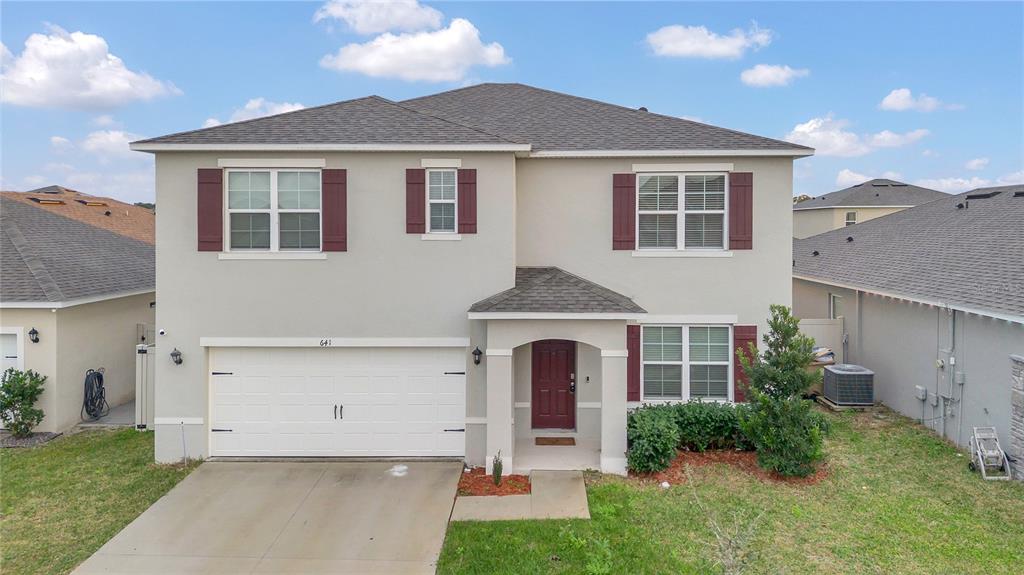 641 Talisi Loop St. Cloud, FL 34771 - Photo 30 of 40 a front view of a house with garden