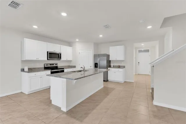 a kitchen with white cabinets stainless steel appliances and a sink
