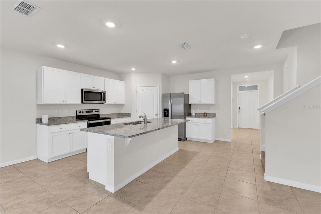 641 Talisi Loop St. Cloud, FL 34771 - Photo 4 of 40 a kitchen with white cabinets stainless steel appliances and a sink