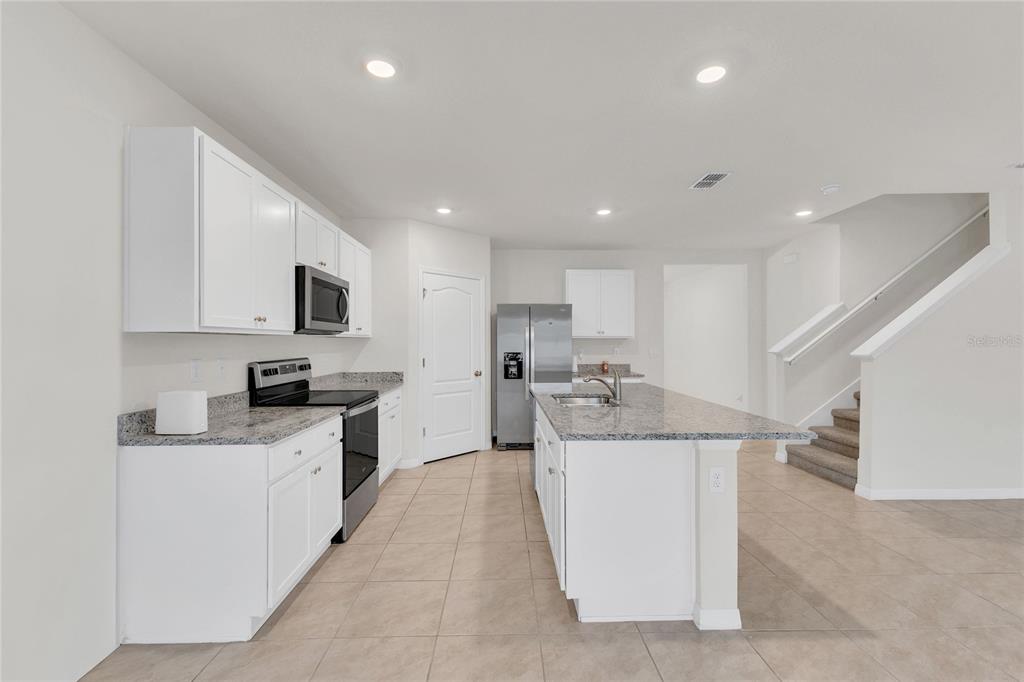 641 Talisi Loop St. Cloud, FL 34771 - Photo 5 of 40 a kitchen with stainless steel appliances kitchen island granite countertop a sink and cabinets