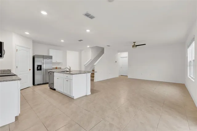 a view of kitchen with stainless steel appliances refrigerator stove microwave and cabinets