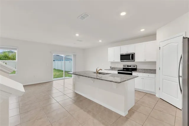 a kitchen with stainless steel appliances a refrigerator sink and microwave