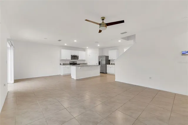 a view of kitchen with kitchen island white cabinets and refrigerator