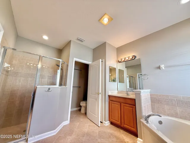 a bathroom with a granite countertop sink a toilet and shower