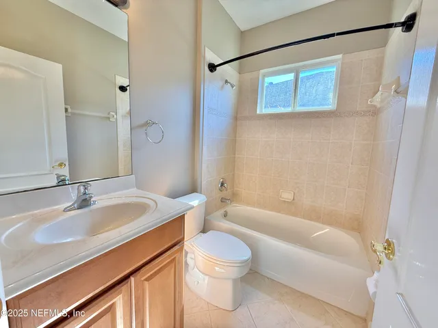 an aerial view of a tennis ground and a cars park side of the road