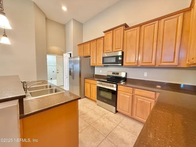 a kitchen with a refrigerator a sink and cabinets