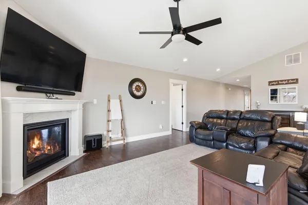 a living room with furniture a fireplace and a flat screen tv