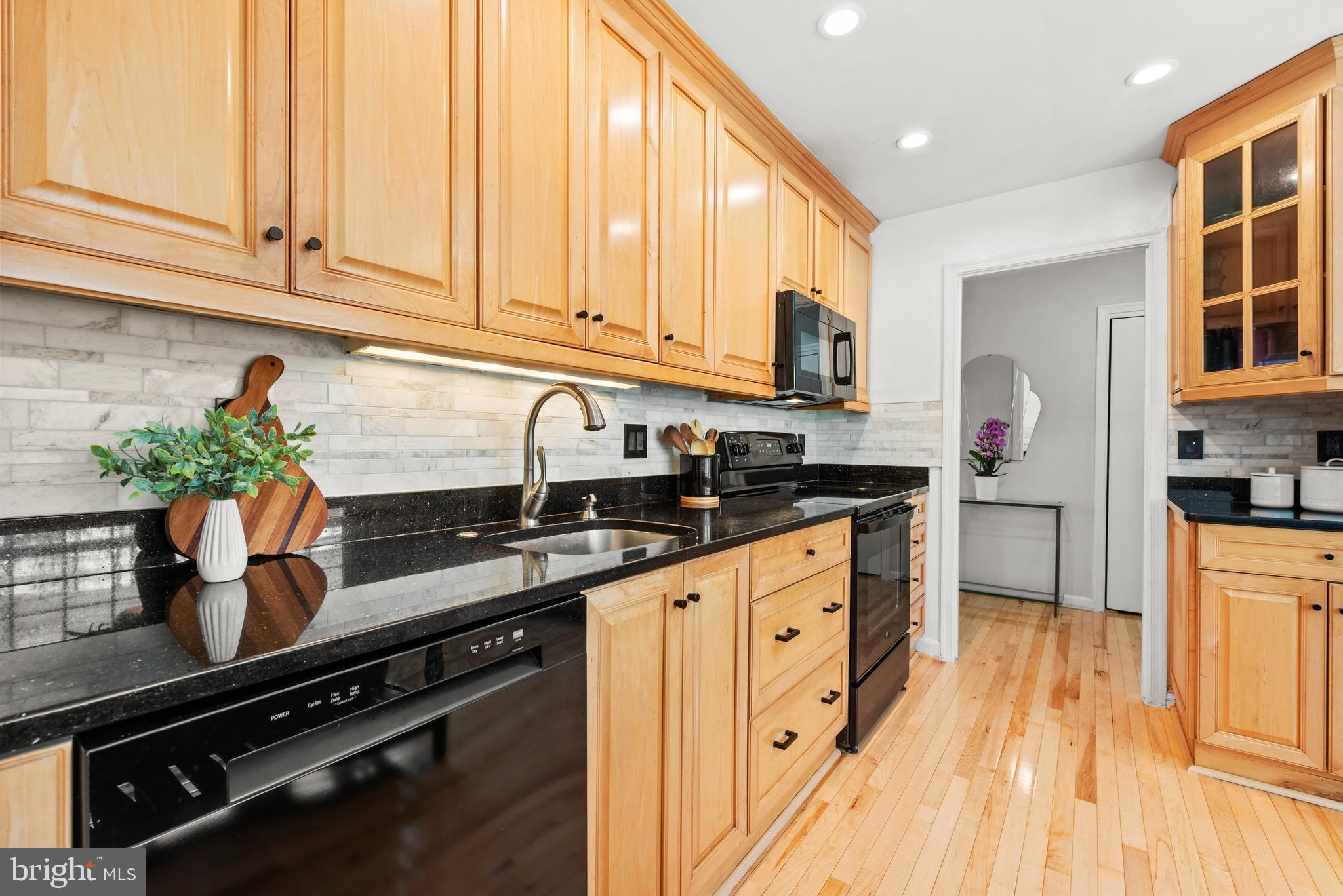 11612 Clipstone Lane Reston, VA 20191 - Photo 14 of 51 a kitchen with granite countertop a sink a stove and cabinets