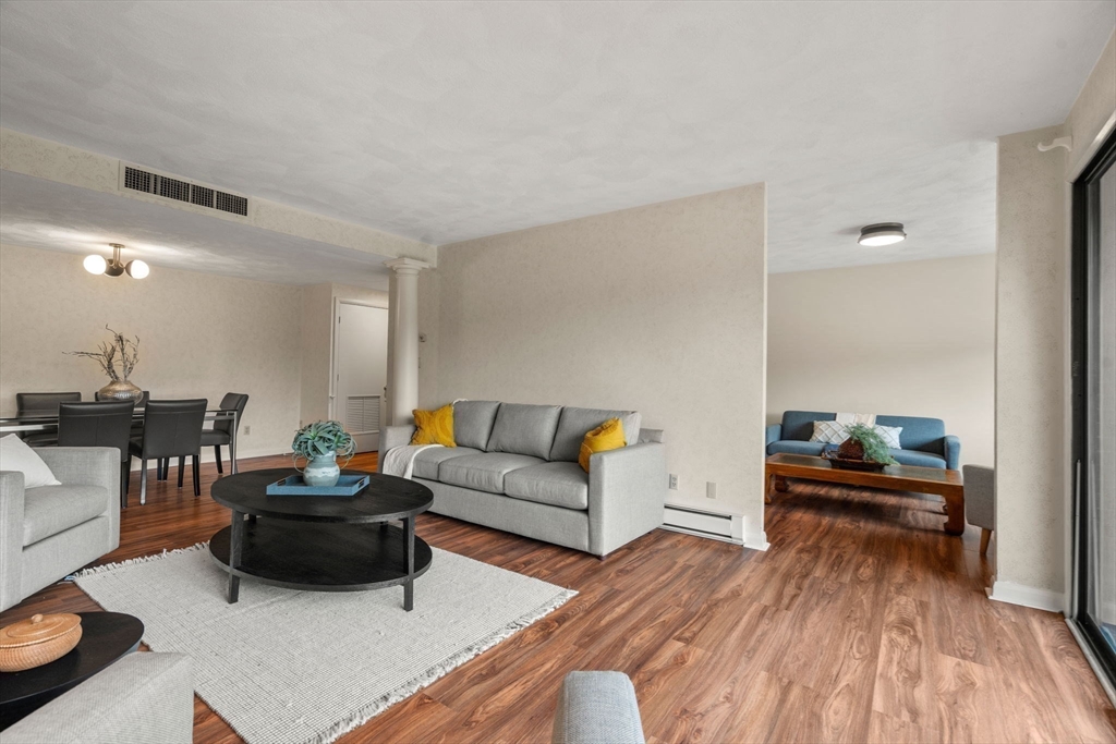 75 Grove Street, Unit 227 Wellesley, MA 02482 - Photo 8 of 29 a living room with furniture and a wooden floor