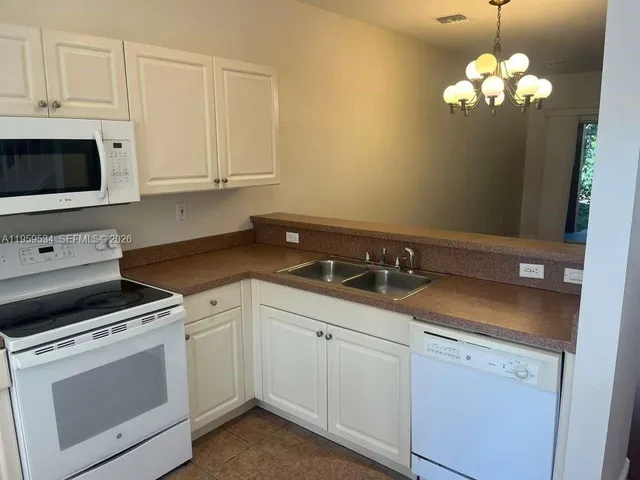 a kitchen with white cabinets and white appliances