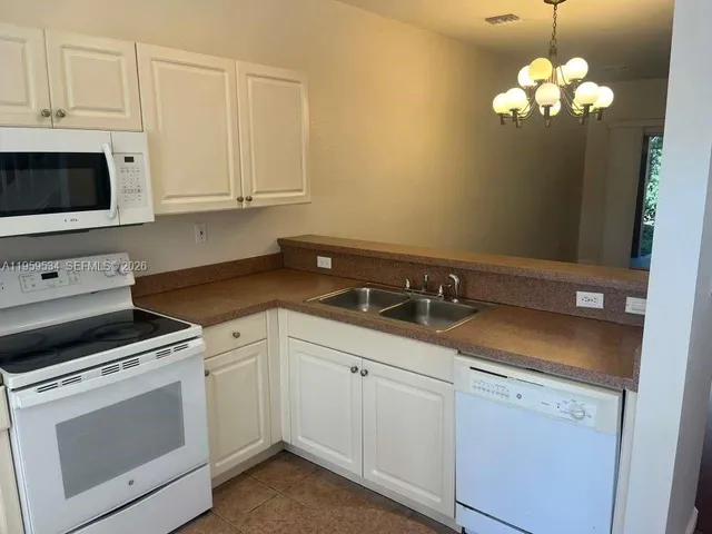 a kitchen with white cabinets and white appliances