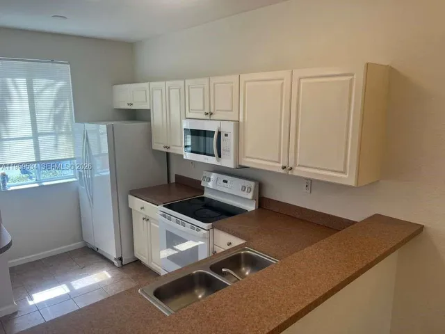 a kitchen with stainless steel appliances granite countertop a stove a refrigerator and a microwave