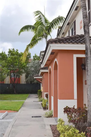 a front view of a house with a garden and trees