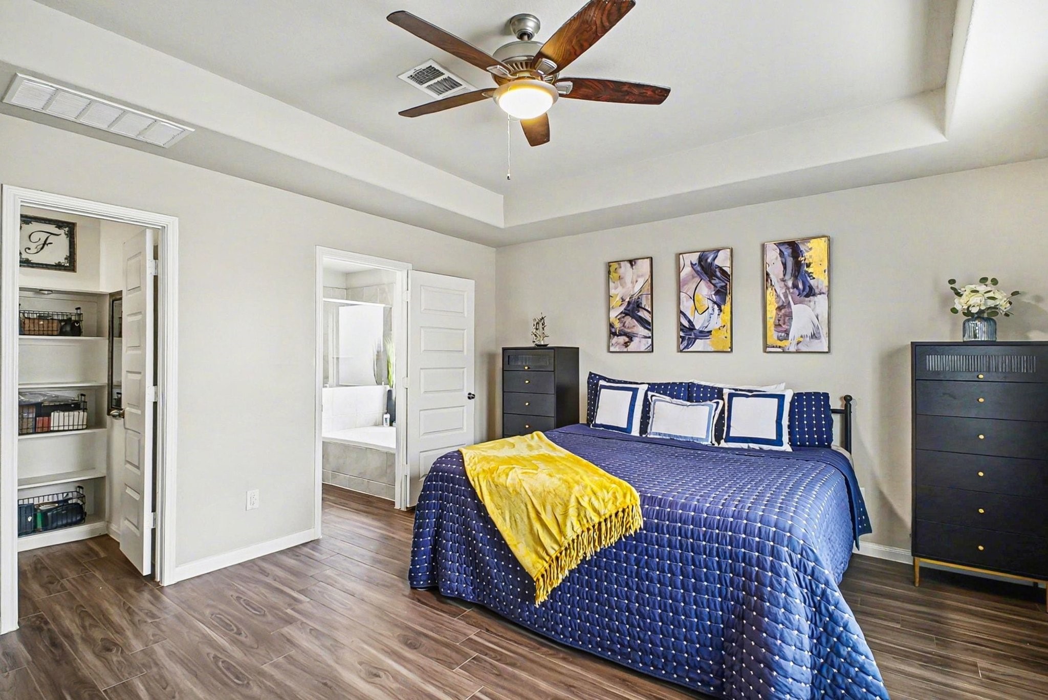 4906 Luke Matthew Drive Rosharon, TX 77583 - Photo 13 of 34 Primary bedroom features a modern and spacious design with wood flooring, a ceiling fan, and a small open closet with shelving adds to the storage options.