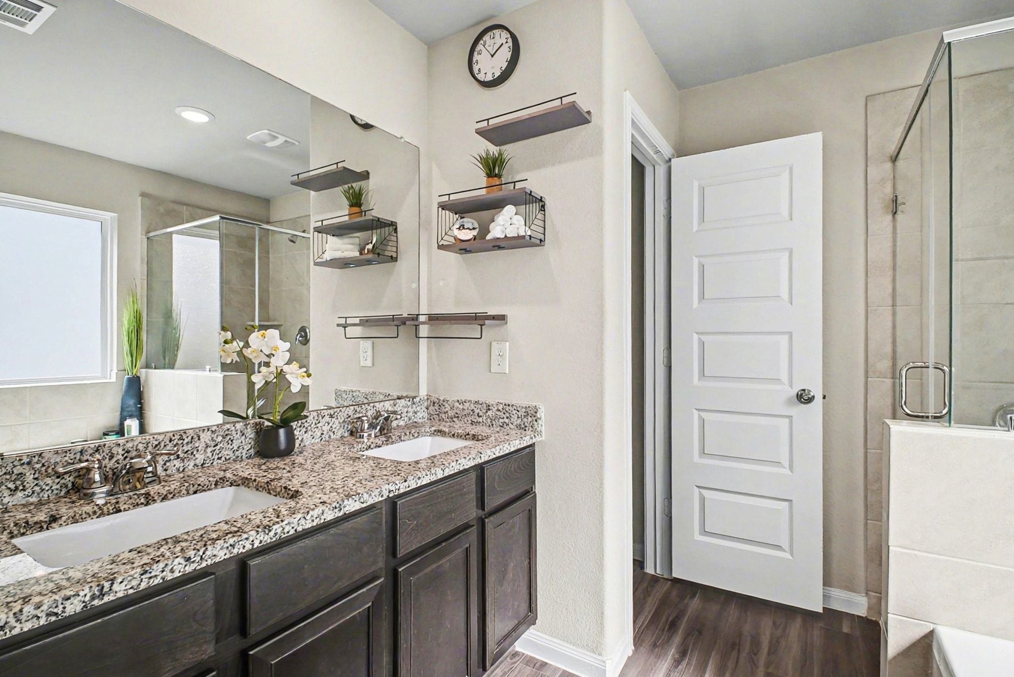 4906 Luke Matthew Drive Rosharon, TX 77583 - Photo 16 of 34 The primary bathroom features a modern design with dual sinks and granite countertops. It includes a glass-enclosed shower, and elegant dark wood cabinetry, providing a sleek and functional space.