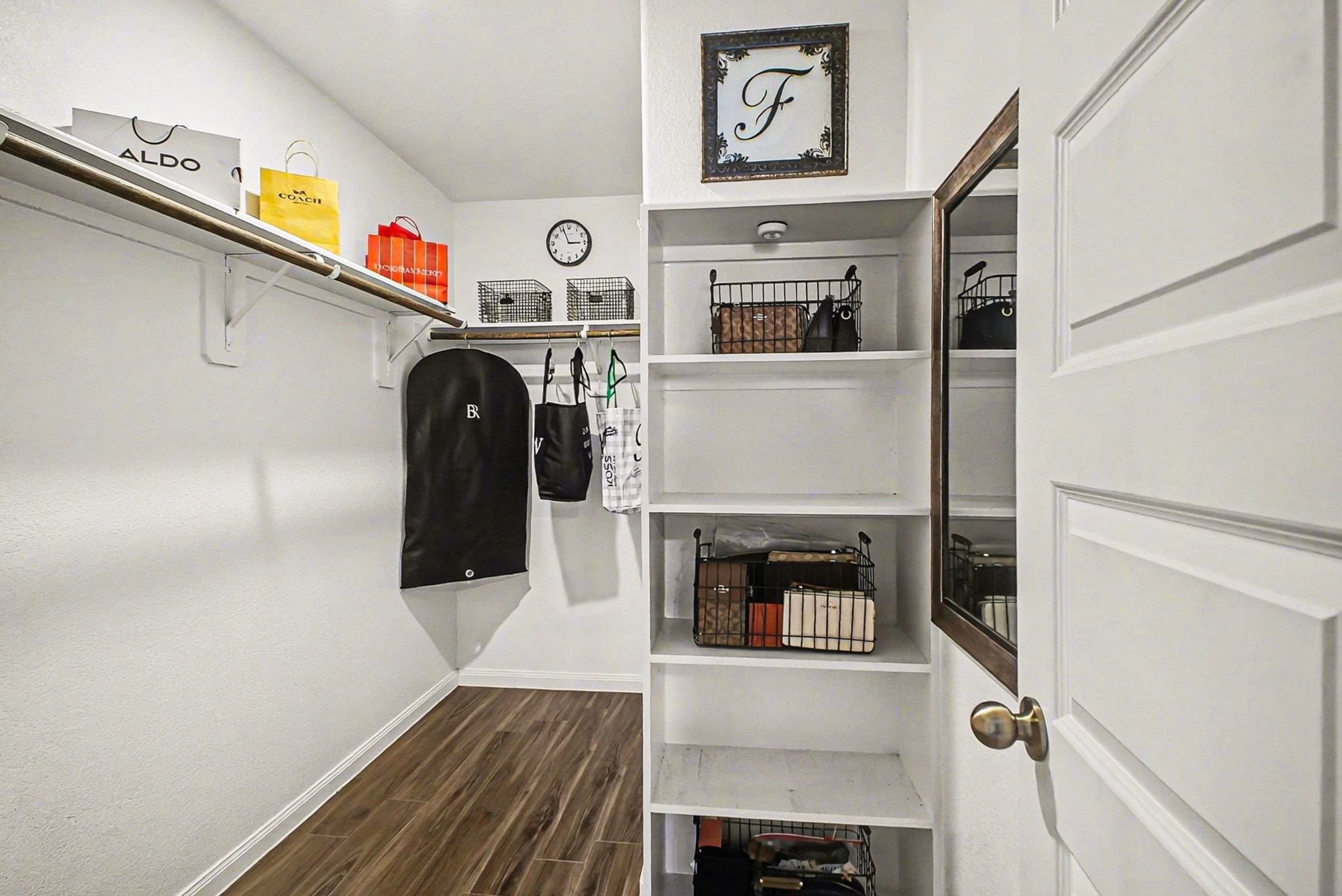 4906 Luke Matthew Drive Rosharon, TX 77583 - Photo 18 of 34 Primary bedroom walk-in closet with ample shelving and hanging space. It features wooden flooring, offering a clean and functional storage area.